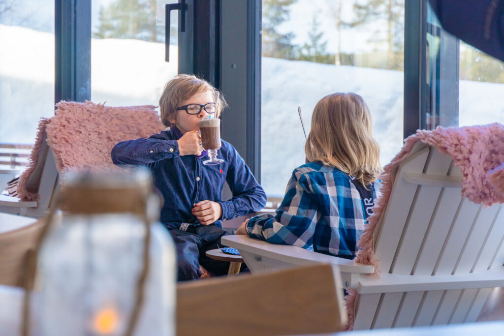Two children enjoying hot chocolates in the Café Ensilumi.