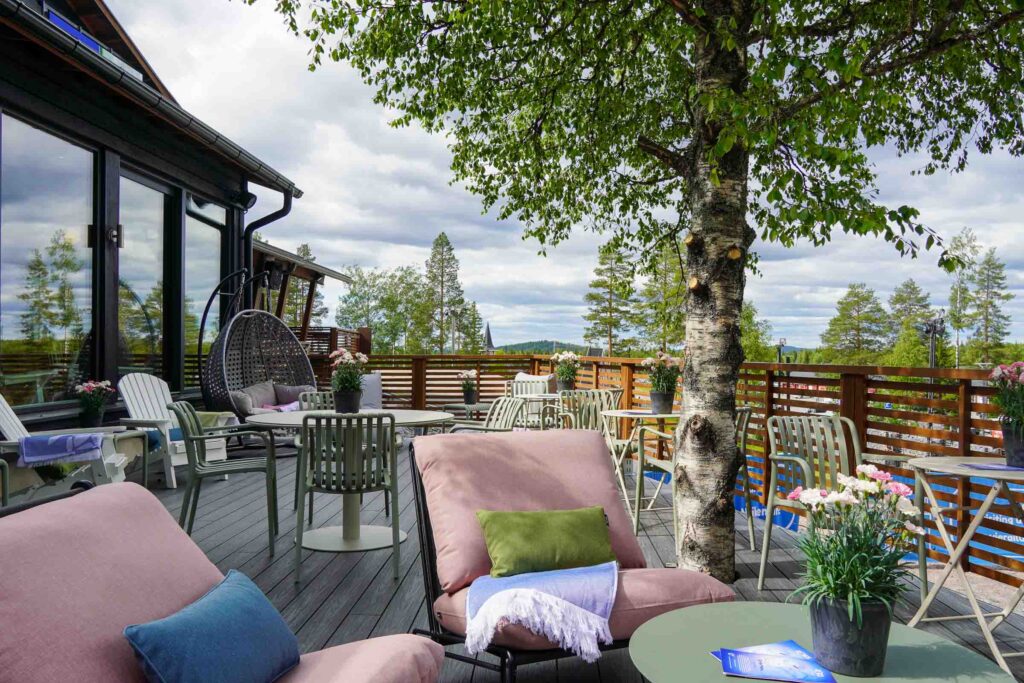 Exterior of Café Ensilumi and outdoor terrace at Snowman World in Santa Claus Village in Rovaniemi.